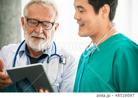 Senior male doctor working with another doctor. Senior male doctor working with another doctor. 48526097