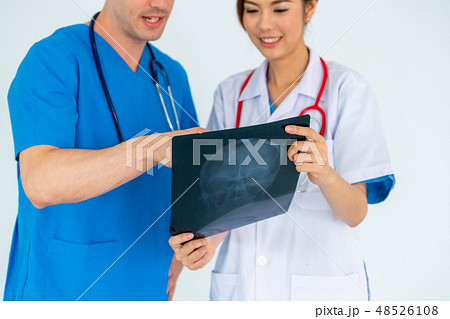 Doctors working with x ray film of patient head. 48526108