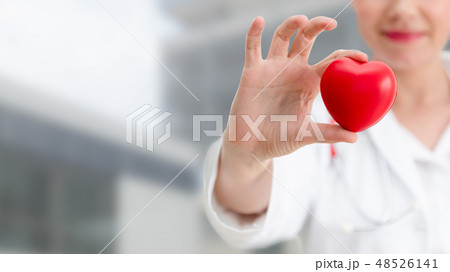 Doctor holding a red heart at hospital office. 48526141