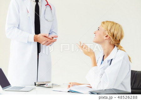 Female doctor at hospital talking to her partner. 48526288