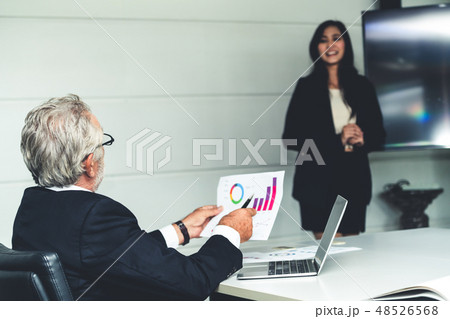 Businesswoman presents senior executive manager. Businesswoman presents senior executive manager. 48526568