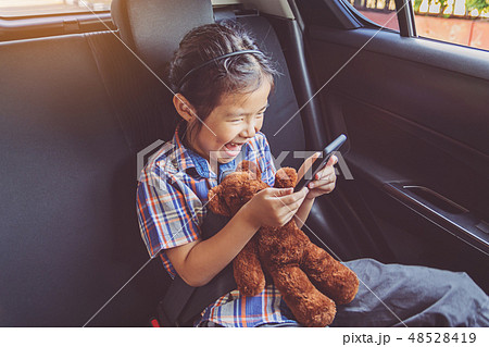 happy little girl wearing seatbelts in car 48528419