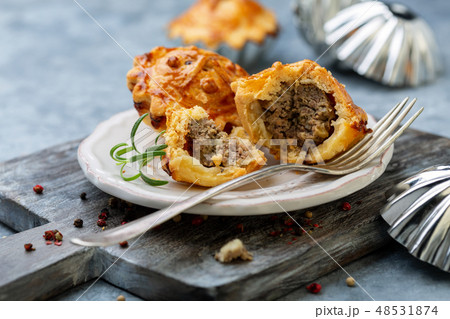 Mini pies stuffed with meat, onion and apple. 48531874