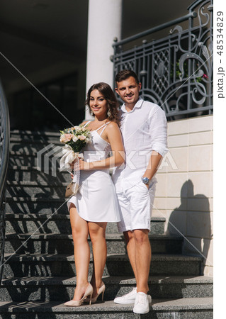 Groom and bride in their wedding day walking in the park. Newlyweds spend time together. Just 48534829