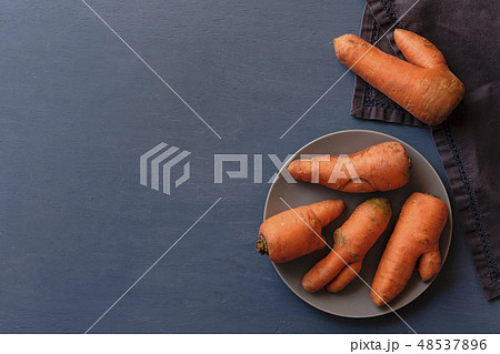 Misshapen ugly fresh carrots on a plate 48537896