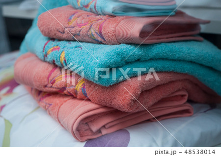 colorful bath towels pile on bed in store 48538014