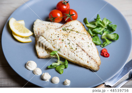 Fried fillet dorado (fish) with tomatoes and lemon 48539756