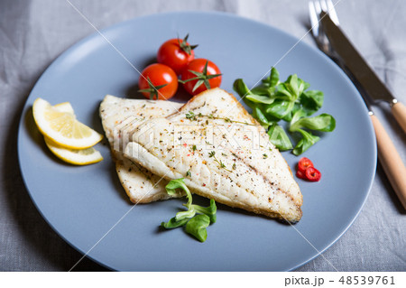 Fried fillet dorado (fish) with tomatoes and lemon 48539761