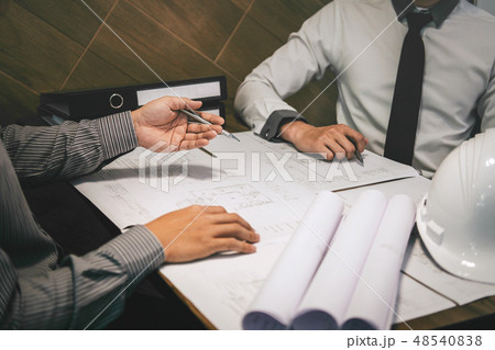 Construction engineering or architect discuss a blueprint while 48540838
