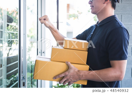 Delivery man standing with parcels in hands outdoors waiting hom 48540932