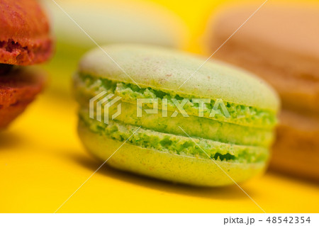 Close up green tea flavour macaroon over yellow background Close up green tea flavour macaroon over yellow background 48542354