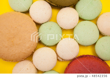 Colorful macaroons cookies cake on yellow background Colorful macaroons cookies cake on yellow background 48542356