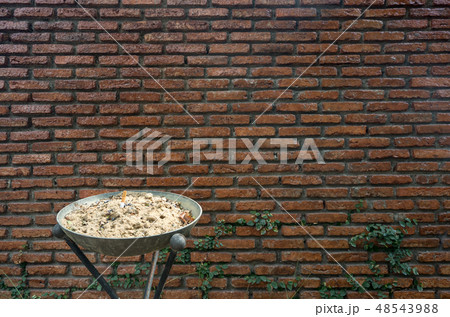 Outdoor metal ashtray with red brick wall Outdoor metal ashtray with red brick wall 48543988