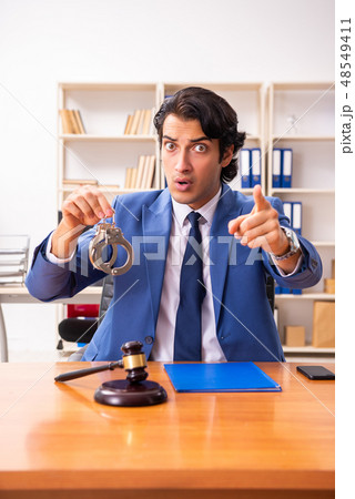 Young handsome judge sitting in courtroom Young handsome judge sitting in courtroom 48549411