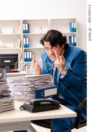 Young handsome busy employee sitting in office  48549413