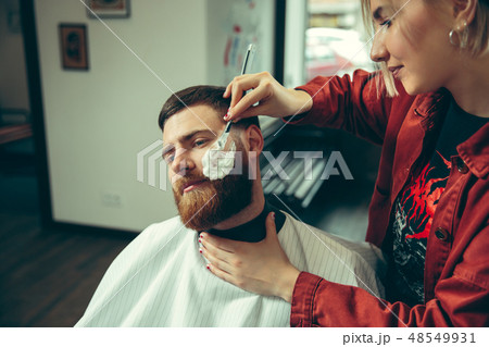 Client during beard shaving in barber shop 48549931