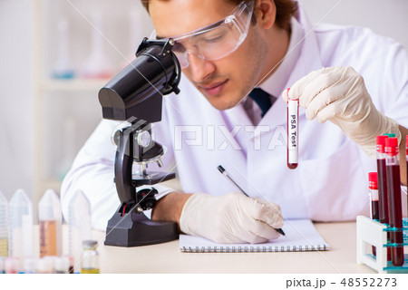 Young handsome lab assistant testing blood samples in hospital  48552273