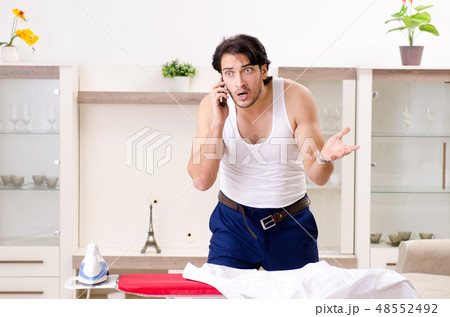 Young man ironing in the bedroom 48552492