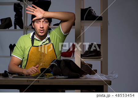 Young shoemaker in workshop at night  48553454