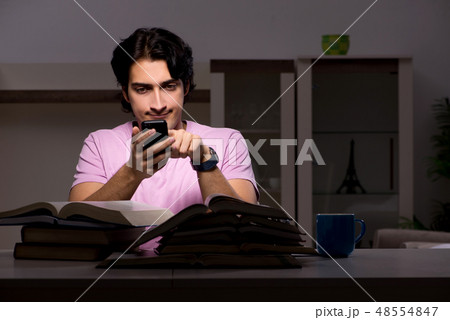 Male handsome student preparing for exams late at home Male handsome student preparing for exams late at home 48554847