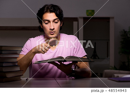 Male handsome student preparing for exams late at home  48554943