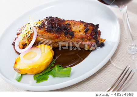 Grilled pork ribs with chocolate sauce and baked potatoes Grilled pork ribs with chocolate sauce and baked potatoes 48554969