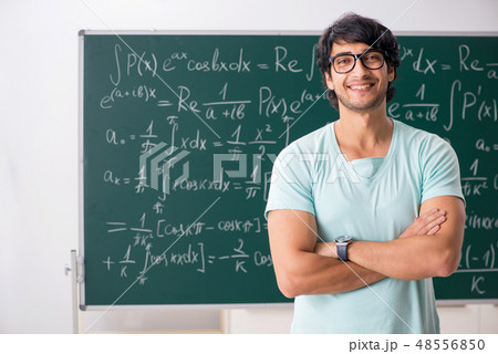 Young male student mathematician in front of chalkboard  48556850