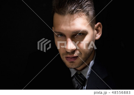 Tricky sly man face in dark room Tricky sly man face in dark room 48556883