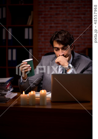 Businessman working late in office with candle light 48557968