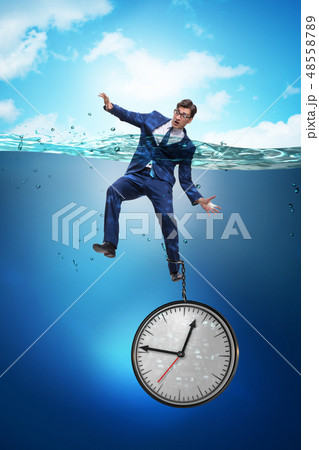 Businessman in deadline and time management concept Businessman in deadline and time management concept 48558789