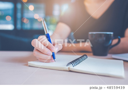 Business woman's hand is writing on a notebook 48559439