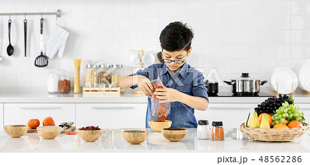 Asian boys are pouring spice powder in wooden. Asian boys are pouring spice powder in wooden. 48562286