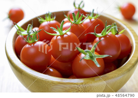 Close-up of fresh, ripe tomatoes on wood bowl 48564790