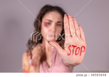 Domestic violence, protesting and people concept - brunette woman expressing denial with STOP on her Domestic violence, protesting and people concept - brunette woman expressing denial with STOP on her 48565648
