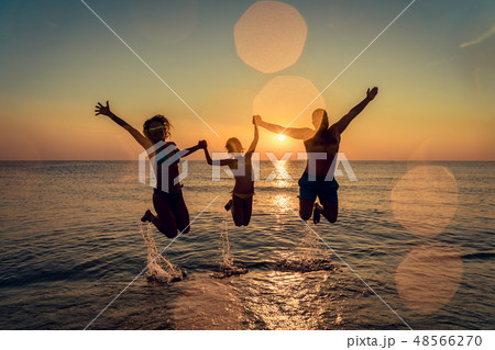 Happy family jumping in the sea 48566270