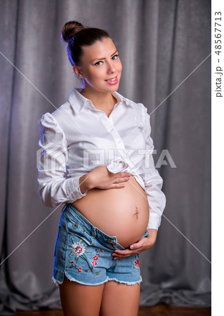 Pregnant happy woman touching her belly Pregnant happy woman touching her belly 48567713