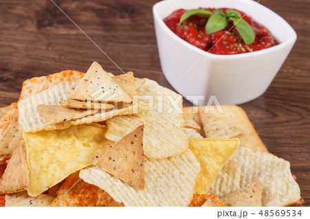Salted potato crisps, cookies and sauce in bowl Salted potato crisps, cookies and sauce in bowl 48569534