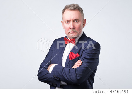 Businessman in blue suit looks at us Businessman in blue suit looks at us 48569591