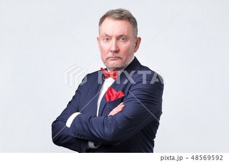 Businessman in blue suit looks at us Businessman in blue suit looks at us 48569592