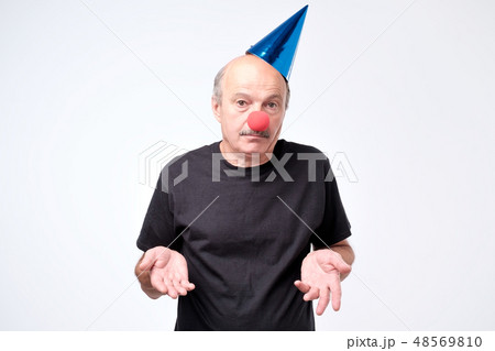 Mature businessman wearing clown nose  48569810