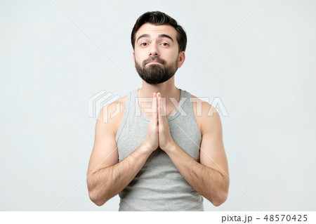 Desperate young man showing clasped hands 48570425