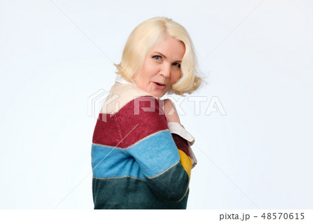Senior woman hides something in her hands   48570615