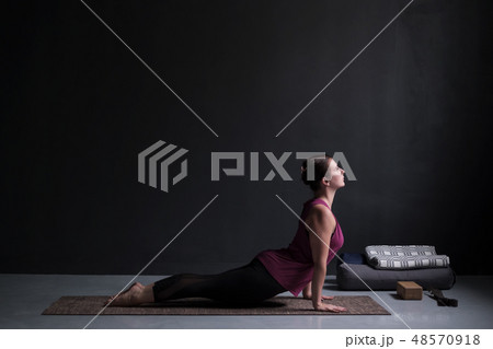 Woman practicing yoga, doing upward facing dog  48570918