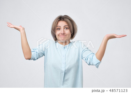 Young girl shrugging shoulders  48571123