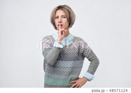 Cute lovely woman keeps fore finger on lips Cute lovely woman keeps fore finger on lips 48571124