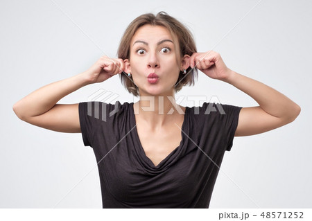 beautiful young woman pulling herself by the ears beautiful young woman pulling herself by the ears 48571252