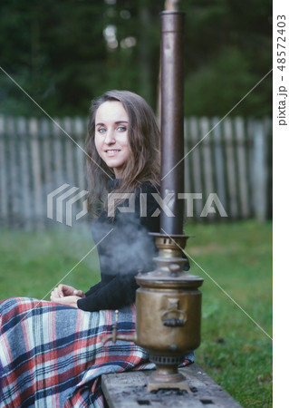Russian woman sitting near the samovar Russian woman sitting near the samovar 48572403