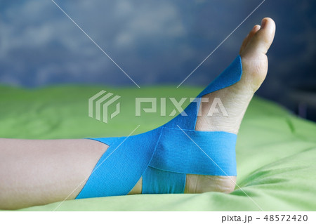 Elastic therapeutic tape applied to patient leg. 48572420