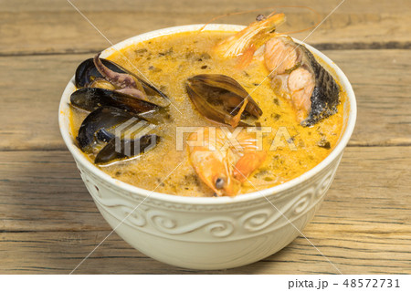 Freshly cooked seafood bouillabaisse soup with shrimps, fish fillets and mussels closeup in a bowl 48572731