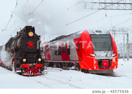 steam locomotive and modern multiple-unit train 48575936